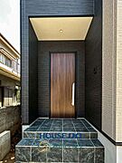 【玄関】シックなタイルと木目調のドアが美しい玄関ポーチ。屋根付きの設計で、雨の日でも落ち着いて出入りできます。