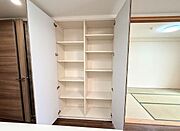 リビング内の大型物入れ。棚板の位置は変えられるので掃除機なども収納できます。