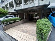 緑豊かなアプローチと屋根付きのエントランス