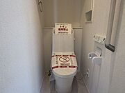 清潔感のある白い空間が広がるトイレです。リモコン付きで操作もスムーズに行え、日々の暮らしに寄り添う快適な設備を整えました。使い勝手の良いシンプルなデザインが、毎日の生活をさりげなくサポートします。