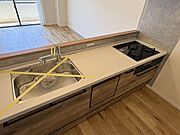リビングを見渡せる対面式のキッチンは、温もりを感じる木目調のデザイン。お料理をしながら家族との会話も弾み、毎日の家事時間がより楽しくなりそうです。明るい陽射しが差し込むやわらかな印象の住まいです。