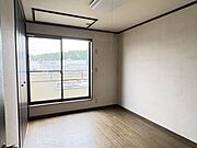 大きなクローゼットを備えた、すっきりと整った洋室です。窓からの眺めが開放感を演出し、お休み前の読書や趣味の時間を心穏やかに楽しめそうな空間です。
