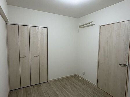 木目調の建具で統一された、温かみのある洋室です。クローゼットを備えた無駄のない設計で、デスクを置いてワークスペースにしたりと、自分好みの落ち着いた空間づくりが楽しめます。