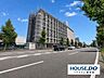 外観：緑豊かな植栽に囲まれたマンション。前面道路や周辺環境との位置関係も確認できます。