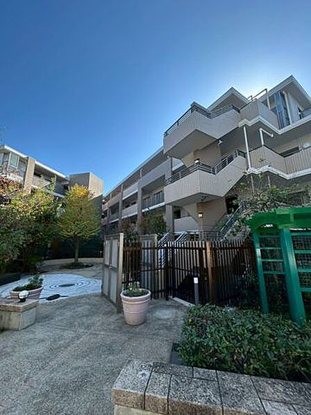 ゆったりとした配置の建物。敷地内には植栽と広場があり、空の広さを感じる伸びやかな住まいです。