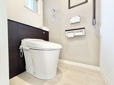 白を基調とした爽やかで気持ちの良いレストルーム。毎日のお手入れがしやすいシンプルなデザインで、上部にはトイレットペーパーなどのストックに便利な吊戸棚(収納スペース)も完備しています。