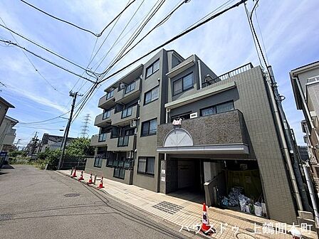 落ち着いた街並みに映えるマンション外観