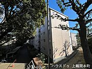 緑の中からそっと顔を出す、鵜野森団地M棟の外観。道路側から望む自然豊かな景観が、毎日の帰り道に安らぎをそえてくれる。ここに暮らすことへの誇りが、静かに芽生えていく。