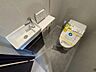 トイレ：手洗い器を備えた清潔感のあるトイレです。温水洗浄機能付きで、快適に使用できます。グレーを基調とした落ち着きのある内装に、すっきりとした設備が調和。独立した手洗い器があり、来客時にも使いやすい空間です。