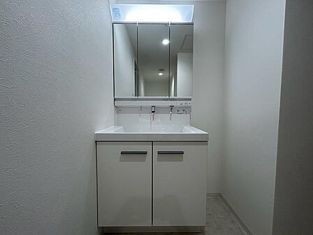 白を基調とした、清潔感のある洗面化粧台。三面鏡で身だしなみを整えやすく、朝の準備もスムーズに進められます。洗面ボウルや下部の収納など、日々使う場所だからこそ、広さや使い勝手を実際に見てご確認ください。