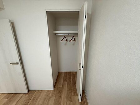 ハンガーパイプと上部の棚を備えたクローゼット。シャツや上着を掛けて収納でき、毎日の身支度の際にも選びやすく便利です。下部に収納ケースを置くなど、持ち物に合わせて工夫でき、お部屋の空間を有効に使えます。
