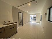 キッチン　別角度。白い壁と明るいフローリングが基調となっており、全体的に開放的でモダンな印象となっています。
