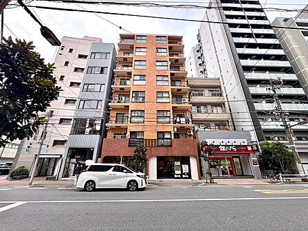 落ち着いた色合いでまとめられたマンションの外観です。建物前には植栽が整えられ、エントランスまわりもすっきりとした印象。周囲の街並みに馴染みながら、整った佇まいが魅力の住まいです。