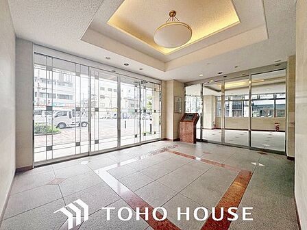 大きな窓から自然光が差し込む、明るく開放的なロビー。高級感のあるソファセットが配置されており、ホテルライクで上質な空間が広がります。来客時の応接スペースとしても重宝します。