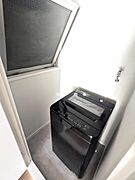 室内の洗濯機を置くスペースです。ドアと窓有ります。貸与される新品の洗濯機が置いてあります。