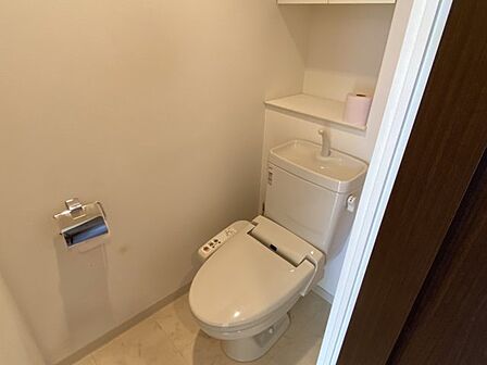 清潔感あふれる温水洗浄便座を完備したトイレ。手洗い場や収納棚も使いやすく配置され、限られた空間でも快適に過ごせるよう配慮されています。落ち着いた内装が安らぎを与え、日々の清潔を保つ最新の仕様。