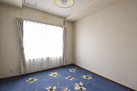 大きな窓から自然光が差し込む、明るくシンプルな洋室です。※現地の撮影写真を基にCG加工編集済