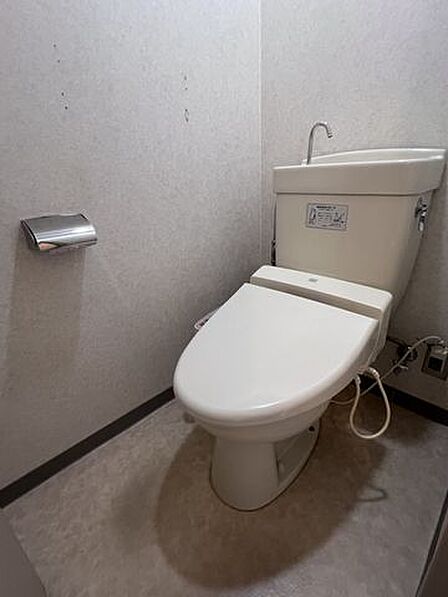 温水洗浄便座を完備した清潔感のあるトイレ。手洗い付きタンクで使い勝手も良好です。