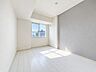 室内：グレーのアクセントクロスがおしゃれな、陽当たりの良い洋室。※現地の撮影写真を基にCG加工編集済