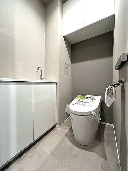 独立した手洗い器が備わった、スタイリッシュなトイレ。吊戸棚にトイレットペーパーなどを収納できます。【トイレ】
