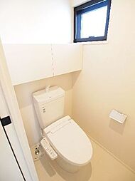 多機能便座付のトイレです。後ろには開き戸の収納スペースがあり、備品を綺麗に収納出来ます。小さいですが採光と換気に役立つ窓もあります。