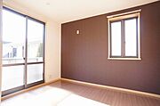 ■5．4帖洋室■　壁の一面にアクセントとして、落ち着いた色合いのカラークロスを採用。家具との相性も良く、空間を優美に彩る。