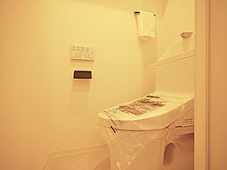 [トイレ] 清潔感あるホワイト調のクロスと温もり溢れるモダンカラーの床材が見事に調和したトイレ。