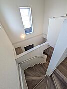 吹き抜けの階段は開放感がある空間です。ストレートではなくカーブがあるので、お子様がいるご家族も安心の仕様ですね♪優しい色合いの床材は温かみがあります。