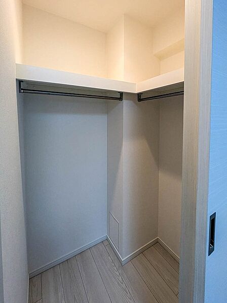 【収納】L字型にパイプを配置したウォークインクローゼット。丈の長い衣類や季節物の保管にも活用できます。
