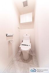 [トイレ] 白を基調に清潔感のあるトイレ。トイレットペーパーホルダーとタオル掛けは標準で実装してます。上部に吊戸棚があり、掃除用具などの収納場所に困りません。