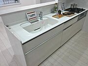 白を基調とした非常にモダンで清潔感のあるキッチン。お料理をしながらリビングやダイニングにいる家族と顔を合わせられるため、孤独感を感じずに家事ができます。