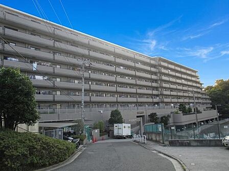2路線利用可能の立地。落ち着いたベージュ系のタイルが美しい、整然としたファサードです。周辺は木々の緑に囲まれ、街の喧騒から少し離れた穏やかな空気が流れています。