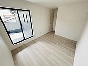 明るい光が差し込む子供部屋です。シンプルな内装で使い方の自由度が高い空間となっています。床面には落ち着いた色合いのフローリングを採用しています。バルコニーへのアクセスもあり通風や採光に優れています。