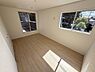 寝室：二面の窓から自然光がたっぷりと差し込む寝室です。シンプルな内装で家具の配置がしやすい設計となっています。広々としたフローリングがゆったりとした空間を演出します。
