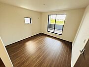 大きな窓から光が差し込み明るさを感じる寝室です。木目調の床が部屋全体を落ち着いた雰囲気にしています。シンプルなデザインで使いやすい空間です。収納やアレンジも楽しめるレイアウトです。