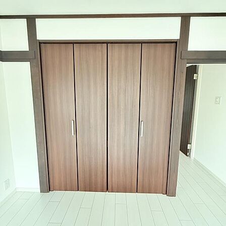 クローゼット扉が木目調で落ち着いた雰囲気です。たっぷり収納できるスペースがあり整理整頓に役立ちます。開きやすいハンドルもポイントです。