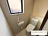 トイレ：アクセントクロスが爽やかでおしゃれな印象を与えるトイレです。手すりやカウンター、小窓が配置されており、機能面と快適性を両立した安心のデザインです。