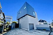 シャープな外観が目を引く建物です。前面道路から敷地内へのアプローチが広く確保されています。駐車スペースもゆとりのある設計で車の出し入れもスムーズです。全体的にシンプルで洗練された印象を与えます。
