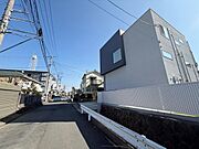 広々とした前面道路で車の出し入れがしやすい環境です。周囲には住宅が建ち並び落ち着いた雰囲気が感じられます。明るい日差しが差し込み開放感のある現地写真です。きれいに整備された道路が印象的です。