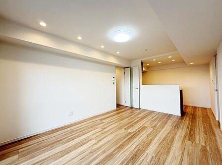 リビングにはダウンライトが多数設置されており天井もすっきりとした印象です。フローリングは自然な木目が感じられる仕上がりで落ち着いた雰囲気を演出しています。