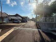 前面道路が広く車の出し入れもスムーズに行えます。周囲には住宅が並び静かな雰囲気が感じられます。日当たりも良好で明るい現地写真が印象的です。道路沿いはしっかりと整備されています。