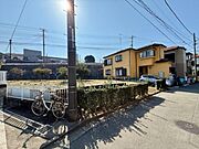 日当たりを感じられる前面道路を含む現地写真です。周囲には住宅が並び落ち着いた雰囲気が広がっています。電柱やフェンスが整然と配置されており道幅も確保されています。