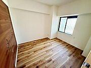窓から光が差し込む明るい洋室です。ナチュラルなフローリングがお部屋全体をすっきりとした印象にしています。壁が白を基調としているためさまざまなインテリアに合わせやすい空間です。