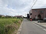 落ち着いた雰囲気の前面道路が広がり周囲には住宅や緑が並ぶ現地写真です。整備された道路は車の出入りもしやすく暮らしやすい環境が感じられます。住まいの周囲も静かな印象です。