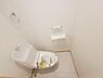 トイレ：シンプルで清潔感のあるトイレ空間です。タオルリングやペーパーホルダーが備え付けられています。床や壁の色合いも明るく全体的にすっきりとした印象です。収納も使いやすい設計となっています。