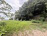 外観：緑豊かな現地土地写真です。周囲には木々が茂り自然を身近に感じられる環境です。開放感のある広々とした土地が広がっています。日当たりも良好でのびやかな印象を与えます。周辺の景色も魅力的に映ります。