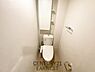 トイレ：シンプルで清潔感のあるトイレ空間です。ホワイトを基調とした内装が明るい印象を与えます。収納棚が設置されているため小物の整理整頓にも便利です。ミラー付きで実用性も備えています。