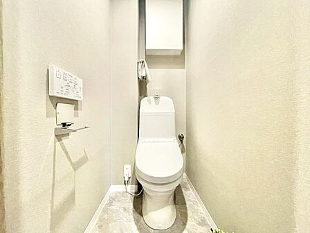 ホワイトを基調とした明るいトイレ空間です。収納スペースも設置されすっきりとした印象です。操作パネルが壁付けで使いやすい仕様になっています。床材もお手入れしやすそうなデザインです。