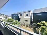 バルコニーからの現地からの眺望は周囲の住宅や庭の緑が広がり開放感を感じられます。陽当たりの良さが印象的で快適な空間です。周囲に遮る建物が少ないため空の広さも楽しめます。
