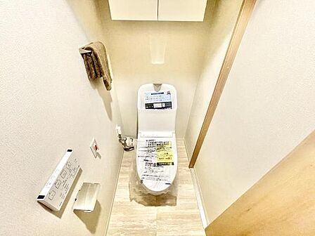 手洗い一体型のトイレが設置され清潔感のある空間です。壁には収納スペースがあり整理整頓しやすく便利です。タオル掛けやペーパーホルダーも設置されており日常の使い勝手が向上します。